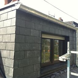 Hier wurde die Dachgaube mit Naturschiefer verkleidet. Fensterlaibung mit schwarzen Aluminium.